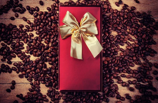 Röda gåva på träbord med kaffe korn — Stockfoto