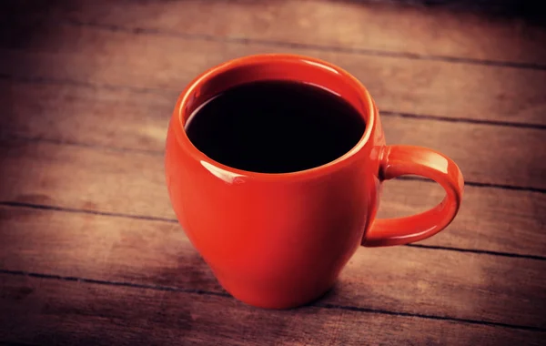 Red cup of coffee on wooden table — Stock Photo, Image