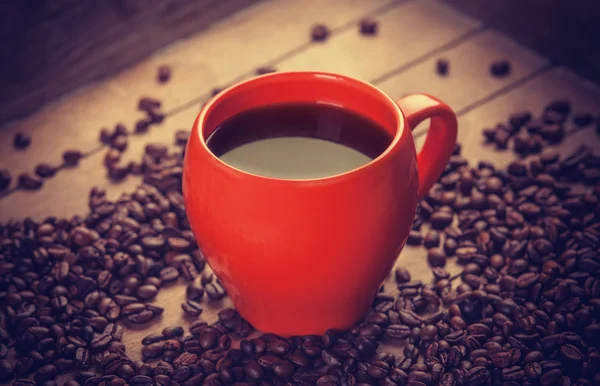 Красная чашка кофе на деревянном столе — стоковое фото