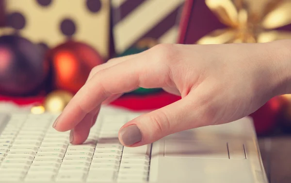 Computer, vrouwelijke hand en de giften van Kerstmis — Stockfoto