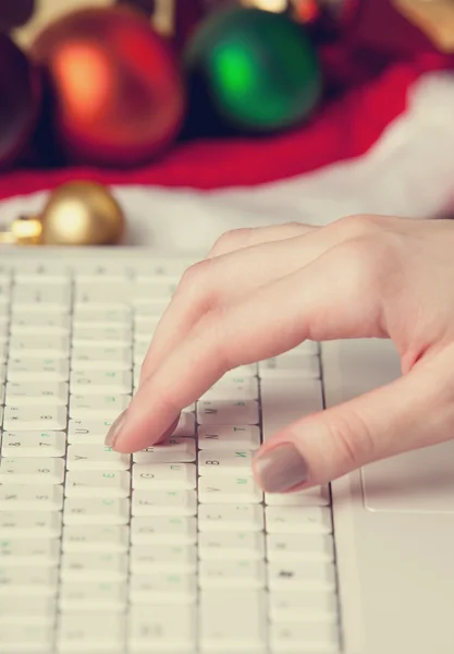 Ordinateur, main féminine et cadeaux de Noël — Photo