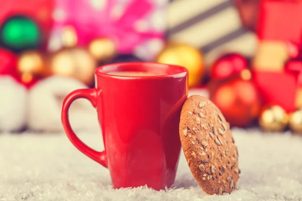 Galletas y taza de café con regalos de Navidad en el fondo —  Fotos de Stock