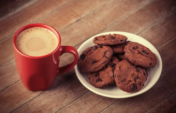 Galletas y taza de café con regalos de Navidad en el fondo — Foto de Stock