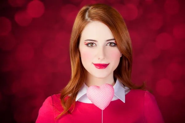 Рыжая девушка с игрушкой в форме сердца . — стоковое фото