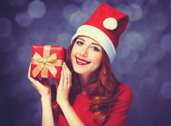 Kızıl saçlı kız mor zemin üzerinde hediyeler ile — Stok fotoğraf