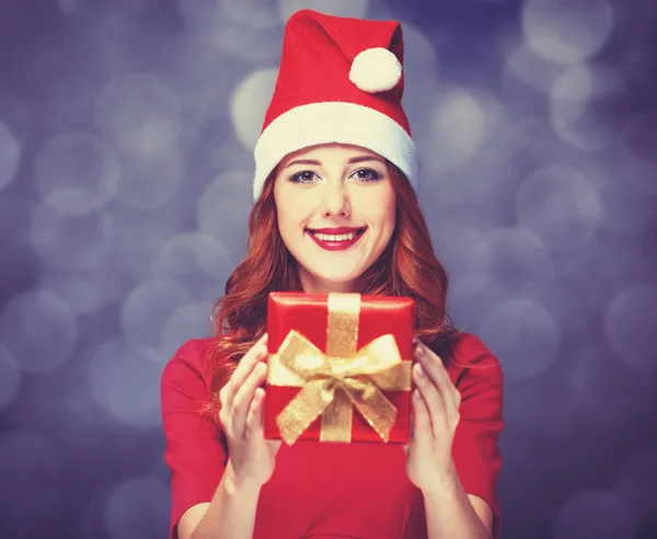 Pelirroja chica con regalos sobre fondo púrpura —  Fotos de Stock