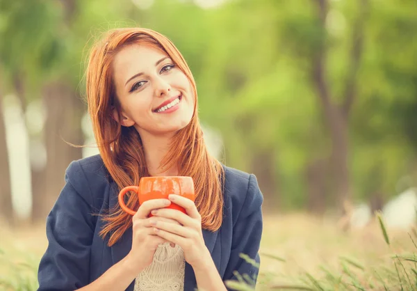 Rödhårig tjej med orange cup på utomhus — Stockfoto