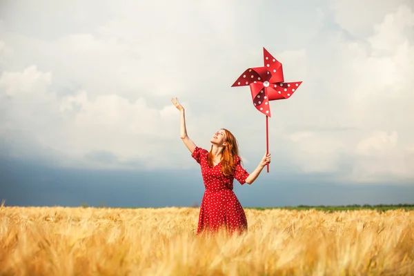 Rödhårig tjej med leksak vindkraftverk — Stockfoto