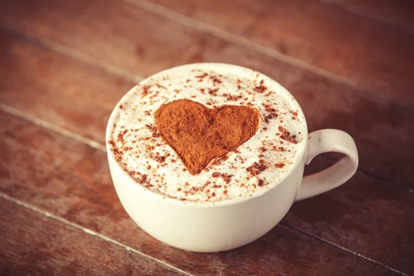 Tasse mit Kaffee und Form des Kakaoherzens darauf. — Stockfoto