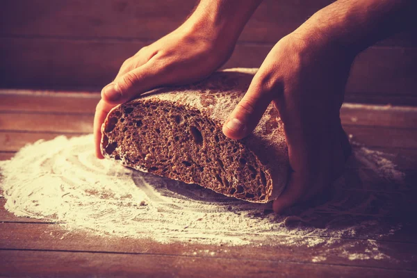 A kenyér Baker kezet. Nagy a kontraszt a fotó — Stock Fotó