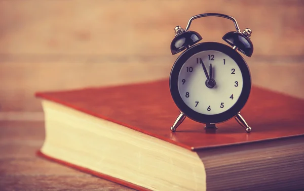 Alarm clock and book. — Stock Photo, Image