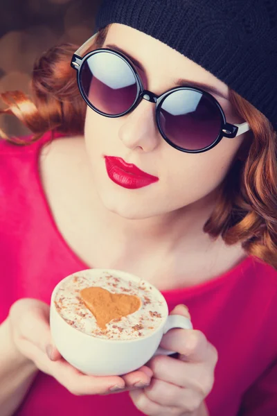 Rudowłosy dziewczyna w okularach z kubkiem kawy. — Zdjęcie stockowe