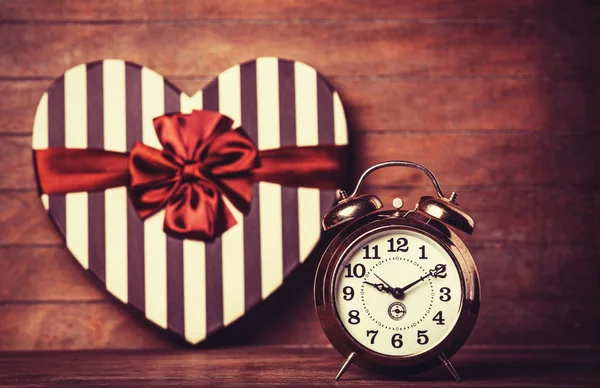 Reloj retro y regalo en forma de corazón en el fondo . —  Fotos de Stock