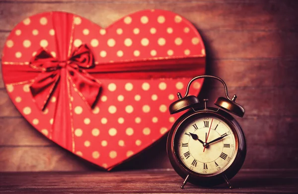 Reloj retro y regalo en forma de corazón en el fondo . — Foto de Stock