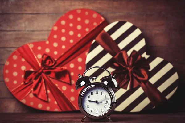 Retro clock and gift in heart shape on the background. — Stock Photo, Image