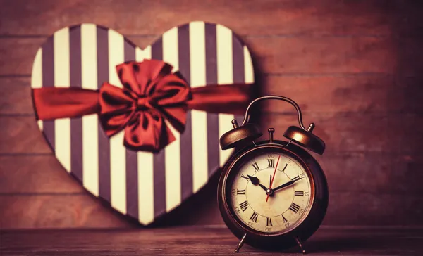 Reloj retro y regalo en forma de corazón en el fondo . —  Fotos de Stock