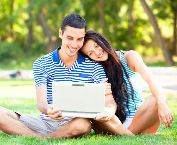 Couple adolescent avec ordinateur portable dans le parc — Photo