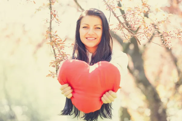 Beautiful girl with toy heart in spring park Royalty Free Stock Images