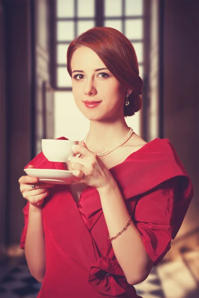 Beautiful redhead women with cup of tea. — Stock Photo, Image