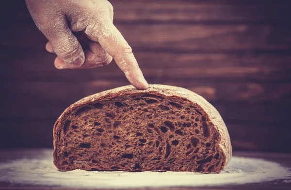 Baker's hands with a bread. — Stock Photo, Image