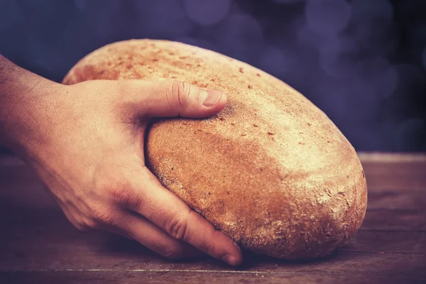 Baker's hands with a bread. — Stock Photo, Image