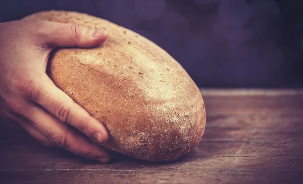 As mãos de Baker com um pão . — Fotografia de Stock