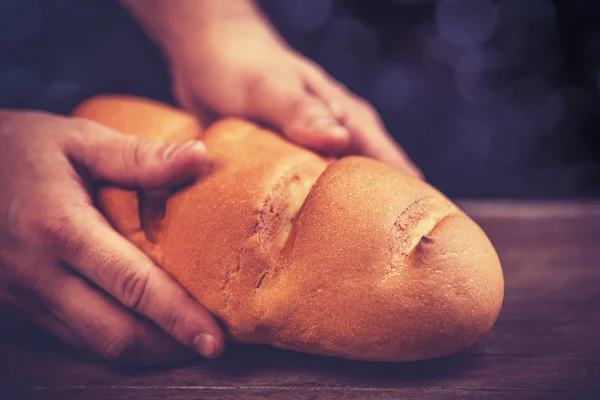 Les mains de Baker avec un pain . — Photo