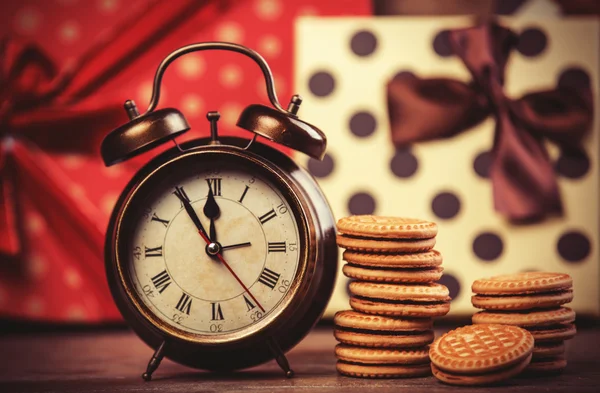 Retro alarm klok met cookie op een tafel. — Stockfoto