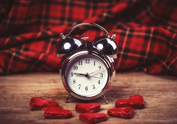 Relógio de alarme retro com biscoito em uma mesa — Fotografia de Stock