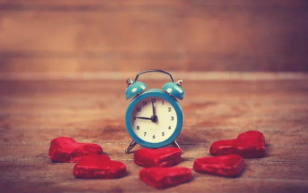 Relógio de alarme retro com biscoito em uma mesa — Fotografia de Stock