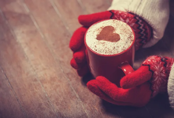 Hands in mittens holding hot cup of coffee — Stock Photo, Image