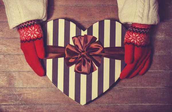 Hands in mittens holding gift box — Stock Photo, Image