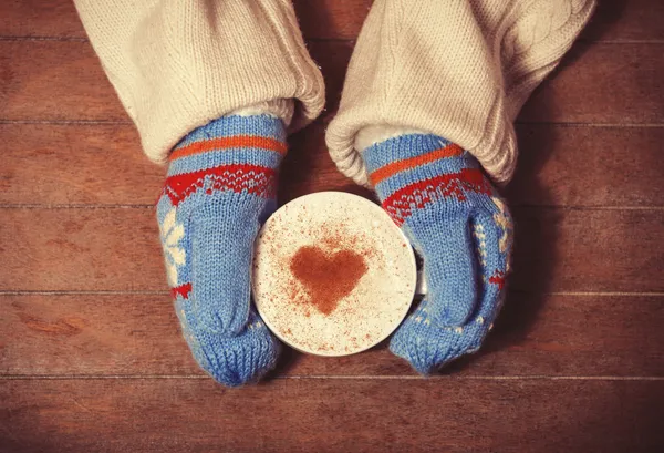 Mãos em luvas segurando xícara quente de café — Fotografia de Stock