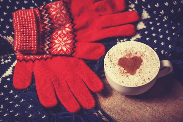 Cup with coffee and shape of the cacao heart on it and scarf. — Stock Photo, Image