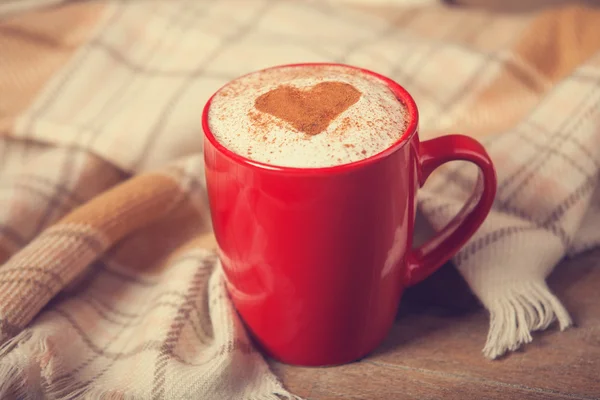 Cup with coffee and shape of the cacao heart on it and scarf — Stock Photo, Image