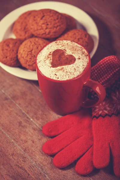 Handschoenen, cookie en cup met koffie — Stockfoto