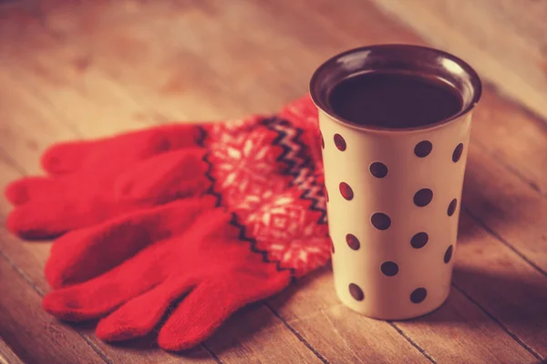 コーヒーのカップと木製のテーブルのミトン. — ストック写真