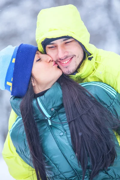 Молодая пара целуется в зимнем парке . — стоковое фото