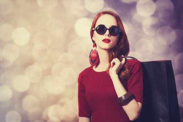 Alışveriş çantası ile güzel kızıl saçlı kadın — Stok fotoğraf