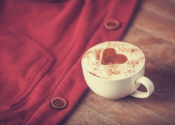 Kopje koffie en rode deel van kleding. — Stockfoto