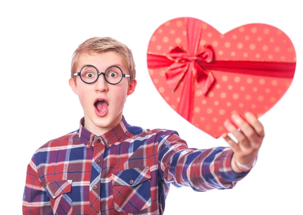 Nerd ragazzo adolescente con regalo a forma di cuore rosso . — Foto Stock