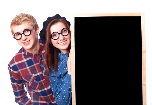 Nerd teen couple with blackboard. — Stock Photo, Image