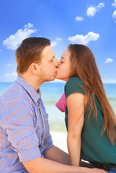 Retrato de homem jovem e mulher beijando em uma praia — Fotografia de Stock