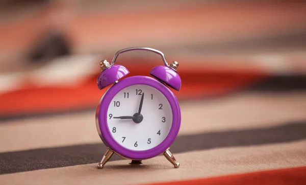 Reloj despertador y bufanda al fondo . — Foto de Stock