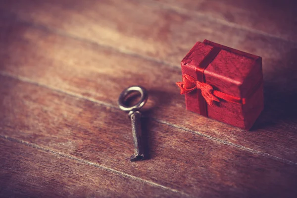 Retro anahtar ve küçük kırmızı bir hediye — Stok fotoğraf