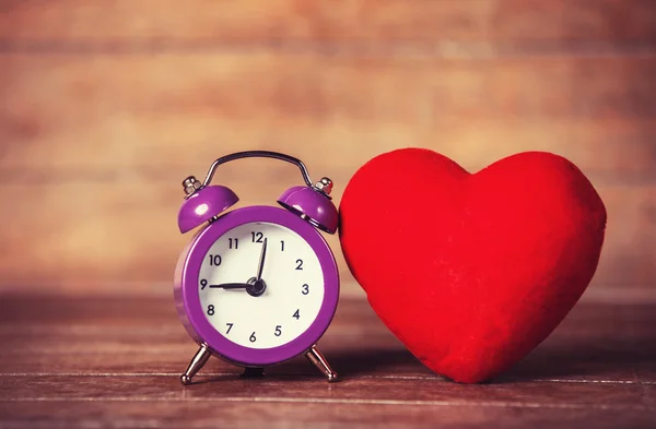Retro alarm clock and heart shape on wooden table. — Stock Photo, Image