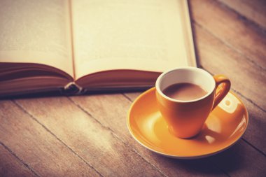 Sarı fincan kahve ve vintage kitap.