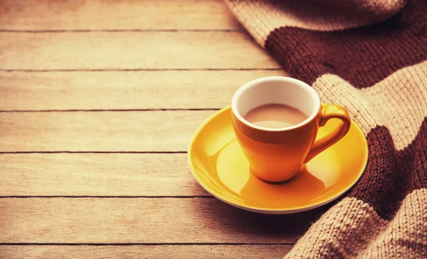Yellow cup of the coffee and vintage scarf. — Stock Photo, Image