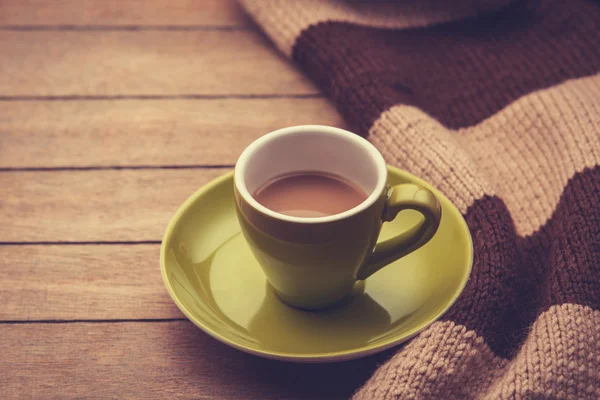 Green cup of the coffee and vintage scarf. — Stock Photo, Image