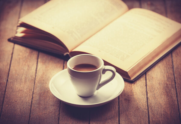 white cup of the coffee and vintage book. 